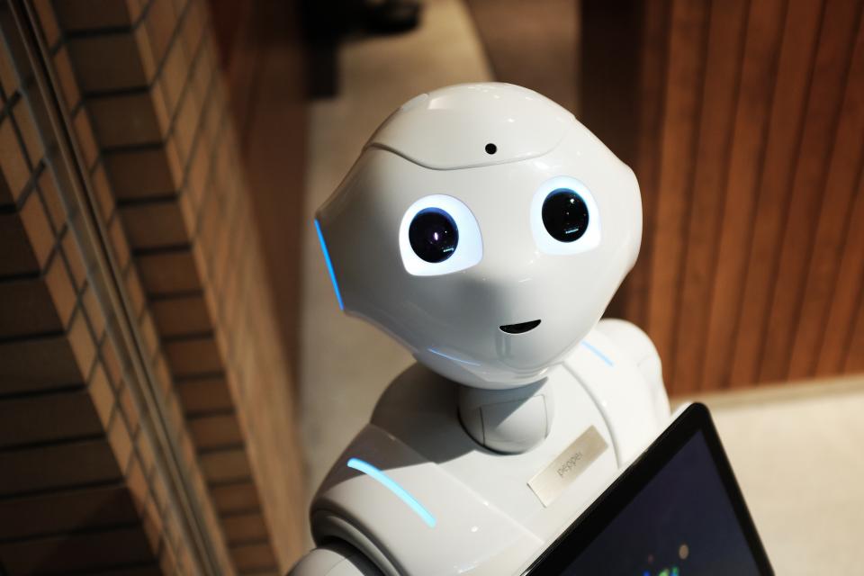 Friendly humanoid robot holding a tablet