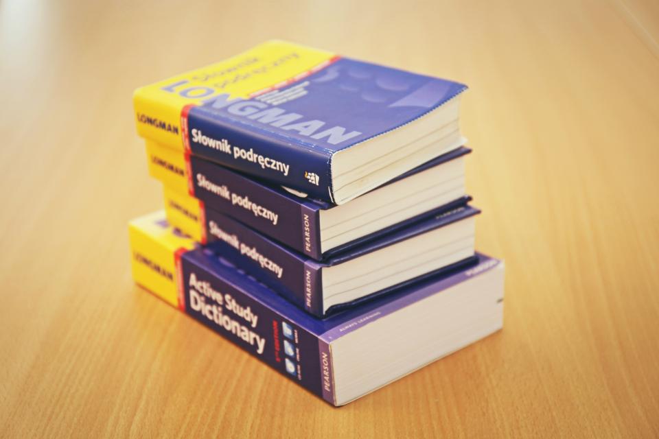 Stack of dictionaries on a wooden table